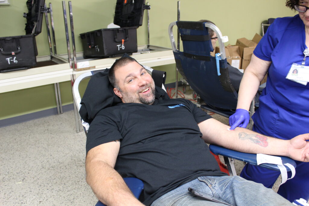 Man giving blood during community outreach at Rosedale Technical College