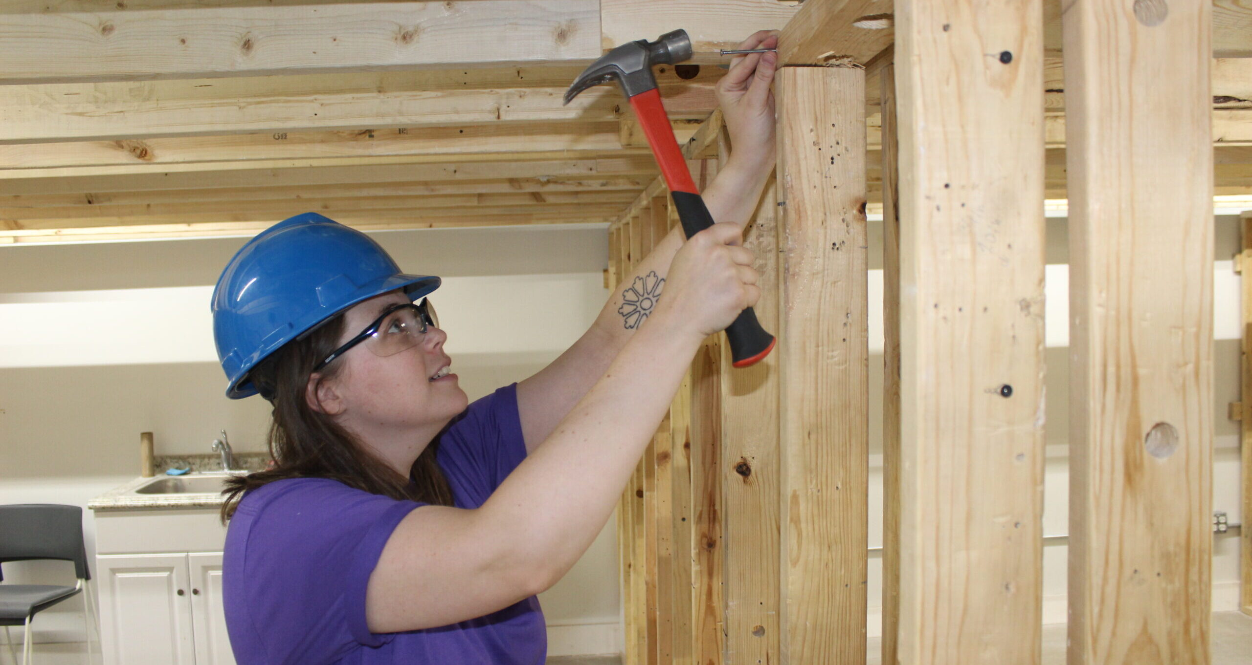 Female Carpenter Using a Hammer to assemble framing